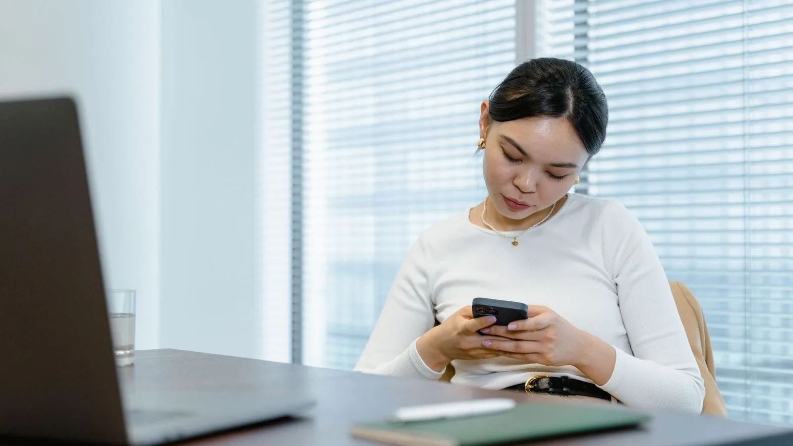 专业人士在办公桌前查看手机上的 WhatsApp 对话